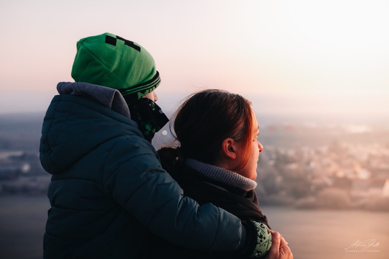 Solange wir gemeinsam schauen Zwei Personen schauen zusammen auf eine weite, malerische Landschaft bei Sonnenuntergang.